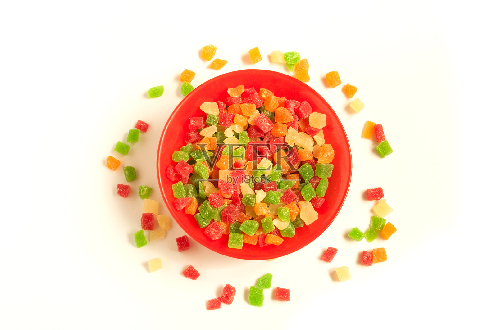 红色的圆形盘子里装满了五颜六色的美味蜜饯水果照片摄影图片