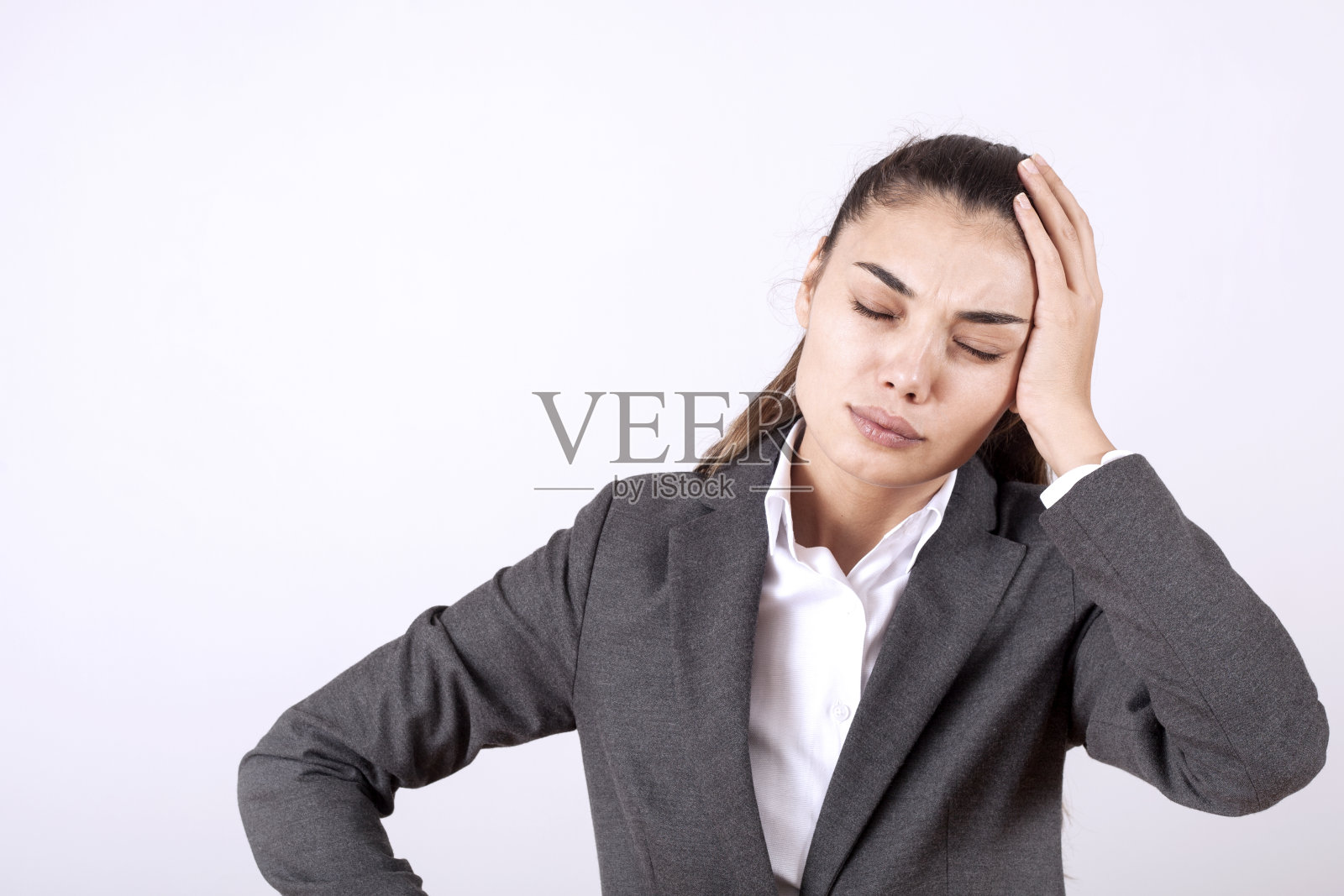 年轻女子站在灰色的垃圾墙疯狂地大喊大叫，带有攻击性的表情和举起的手臂。挫折照片摄影图片