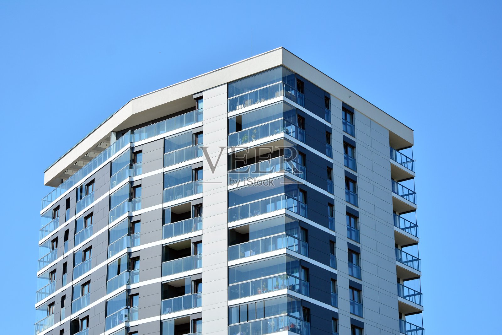 现代化的公寓大楼在一个晴朗的日子与蓝天。现代公寓楼的立面照片摄影图片