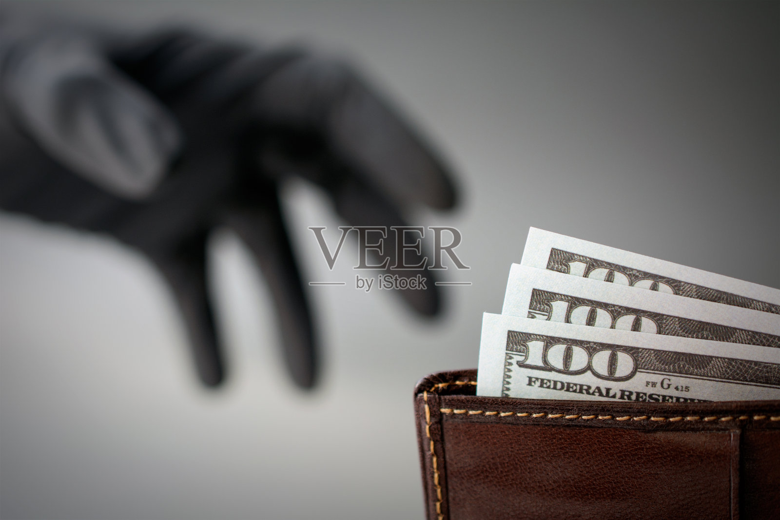 一个戴着黑手套的小偷从钱包里偷钱照片摄影图片