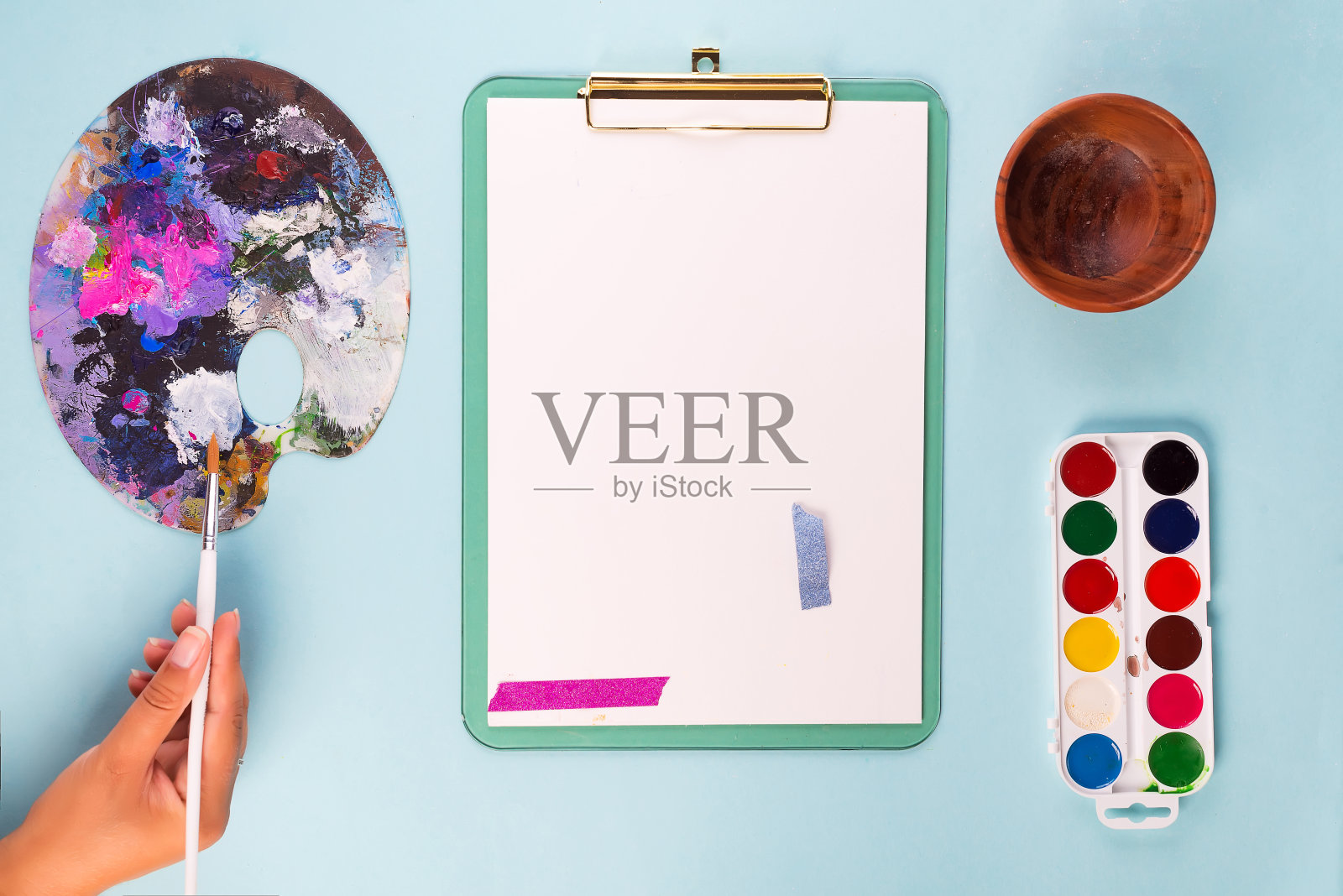 剪贴板与水彩颜料盒，在画笔和调色板上的蓝色桌子。前视图。本空间照片摄影图片