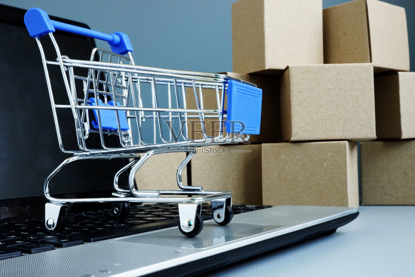 电子商务和网上购物的概念。笔记本电脑上的盒子和购物卡。照片摄影图片