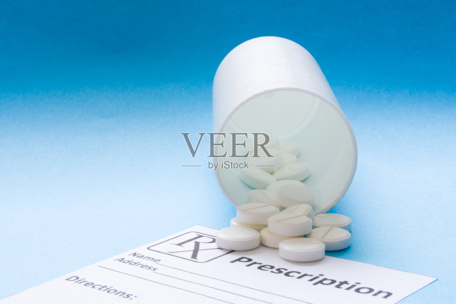 白色药丸或片剂溢出白色容器的药物，白色蓝色梯度背景的纸处方处方。用于制药工业、医药、治疗、药品的图片照片摄影图片