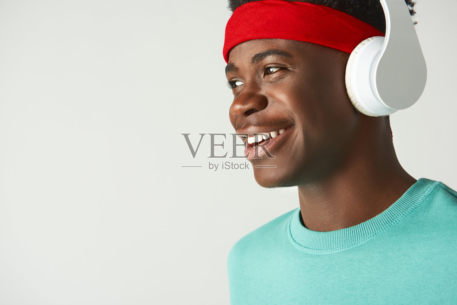 快乐的非洲裔美国人戴着耳机站着照片摄影图片