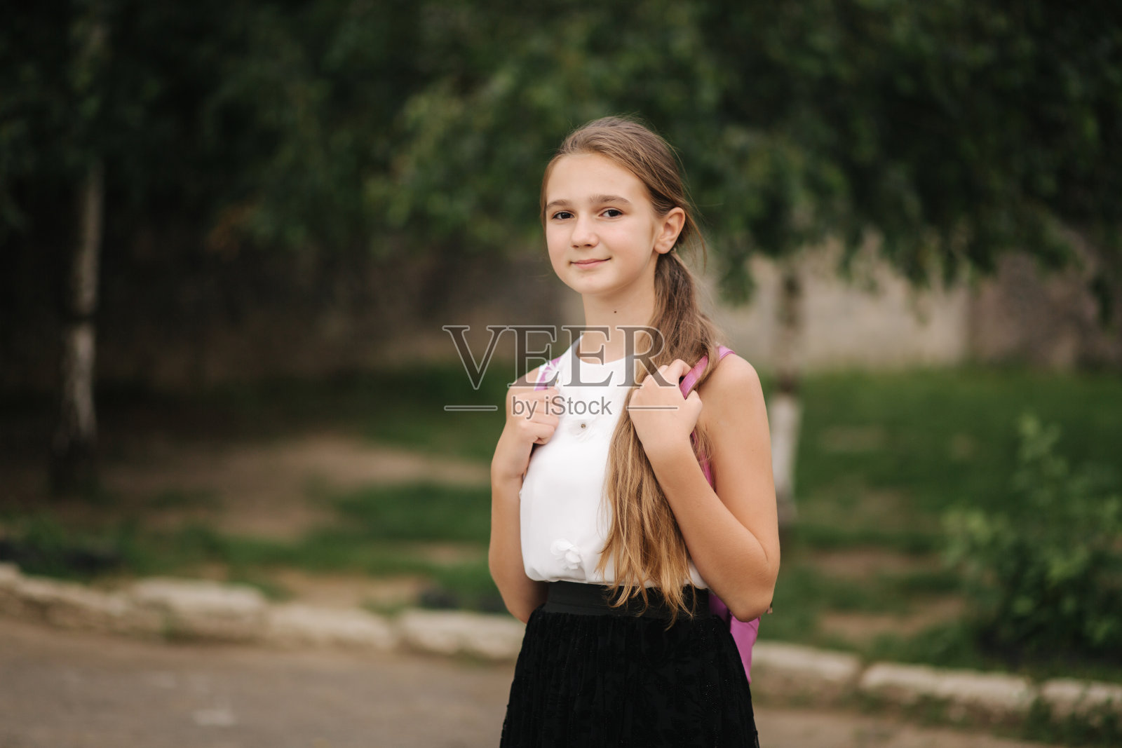 小女孩背着背包在公园里散步照片摄影图片