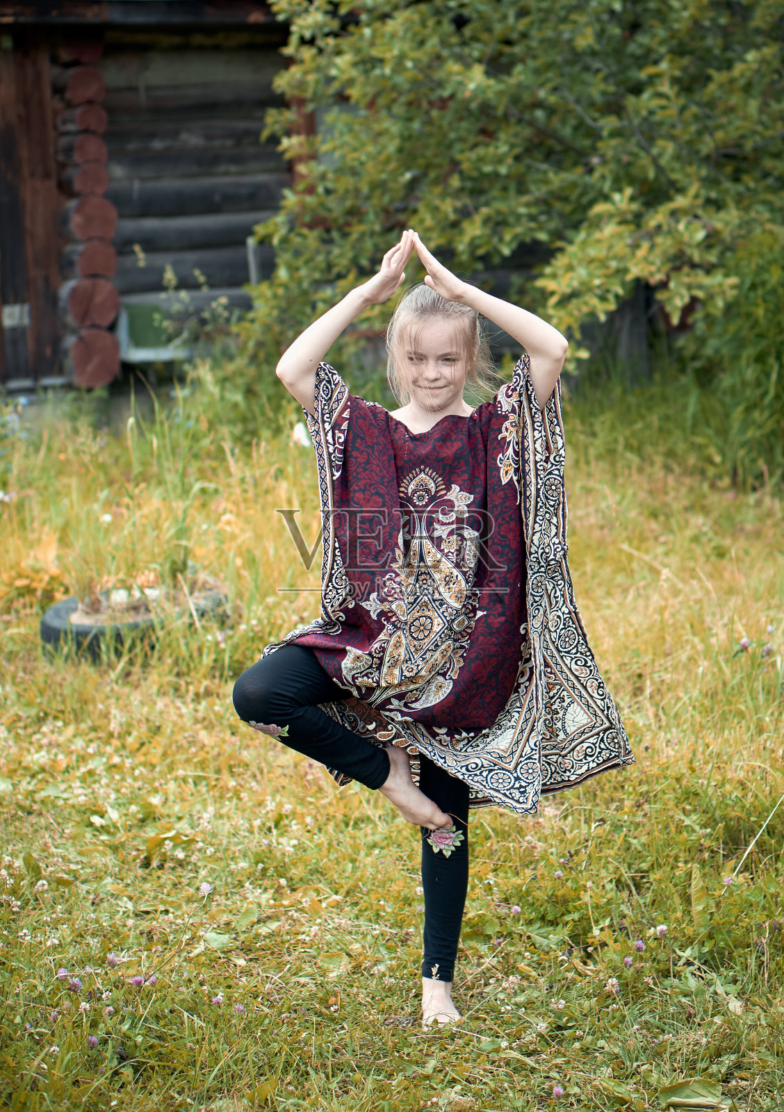 年轻女孩做瑜伽树姿势，户外，夏天照片摄影图片