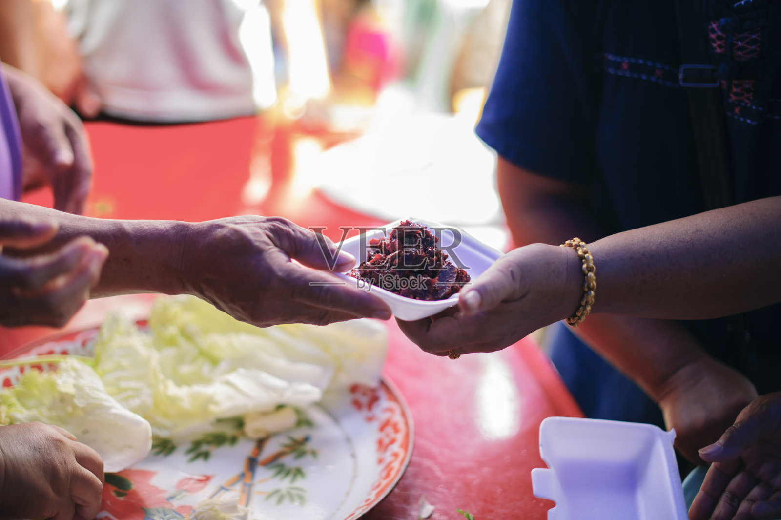穷人接受捐赠的食物:无家可归的人得到食物救济，饥荒救济:志愿者给急需食物的穷人照片摄影图片