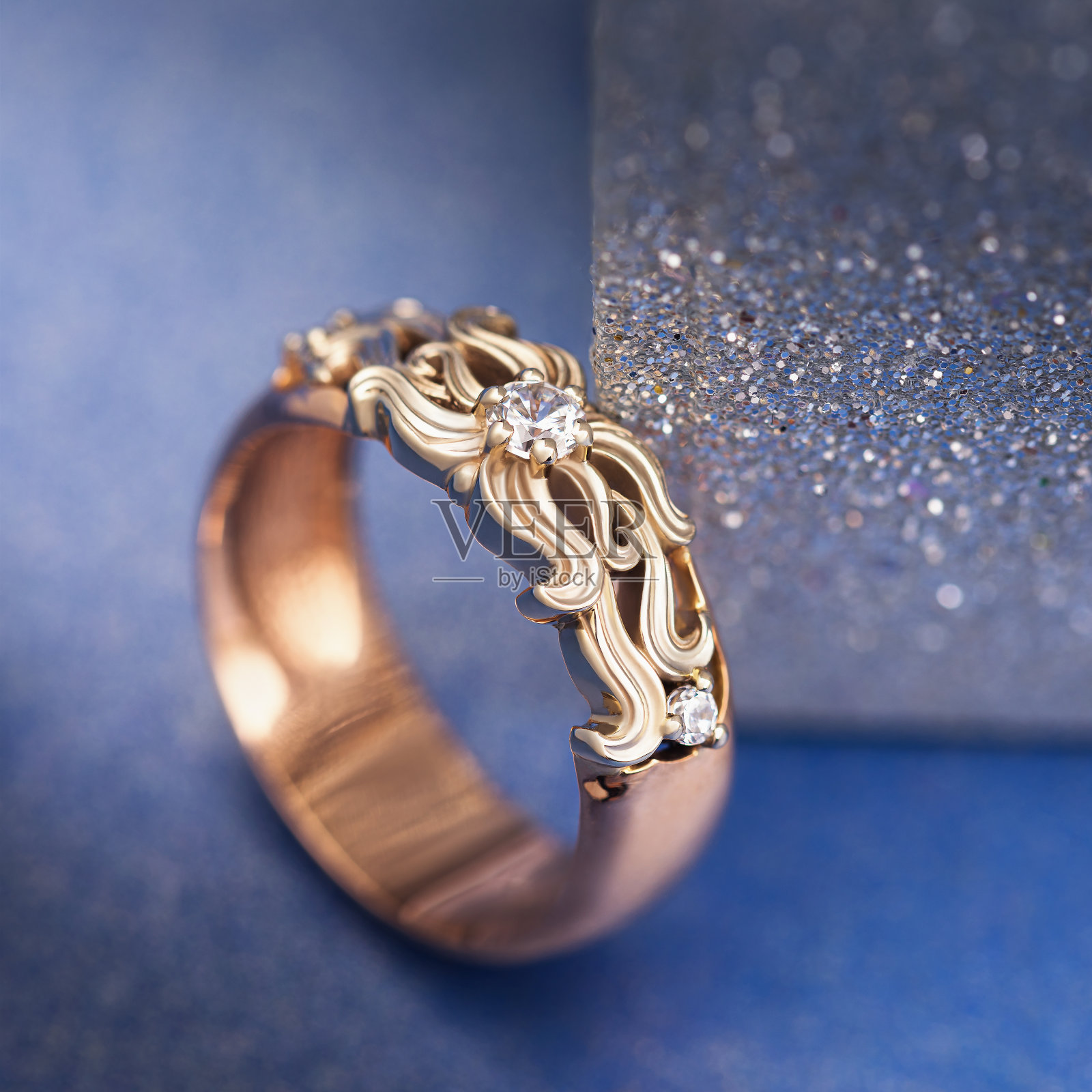 金色的戒指与宝石在蓝色的背景，特写照片摄影图片