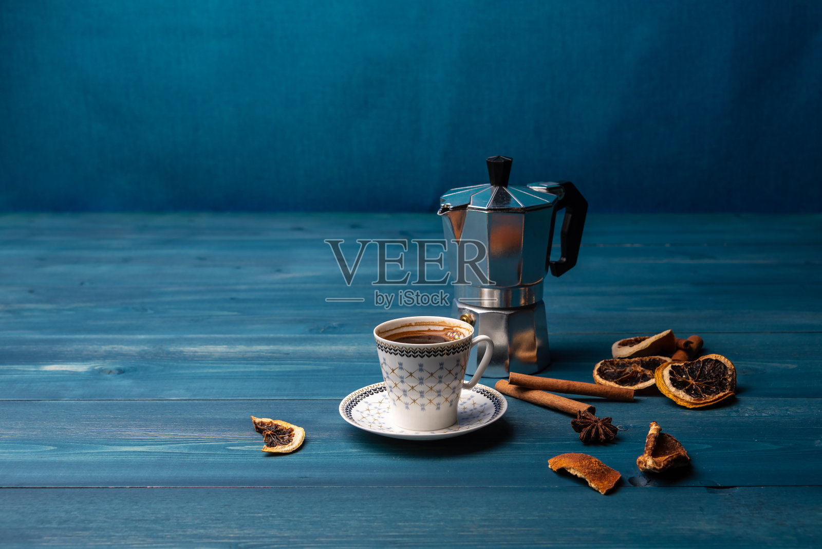 蓝色的木桌上放着一杯咖啡和咖啡壶照片摄影图片