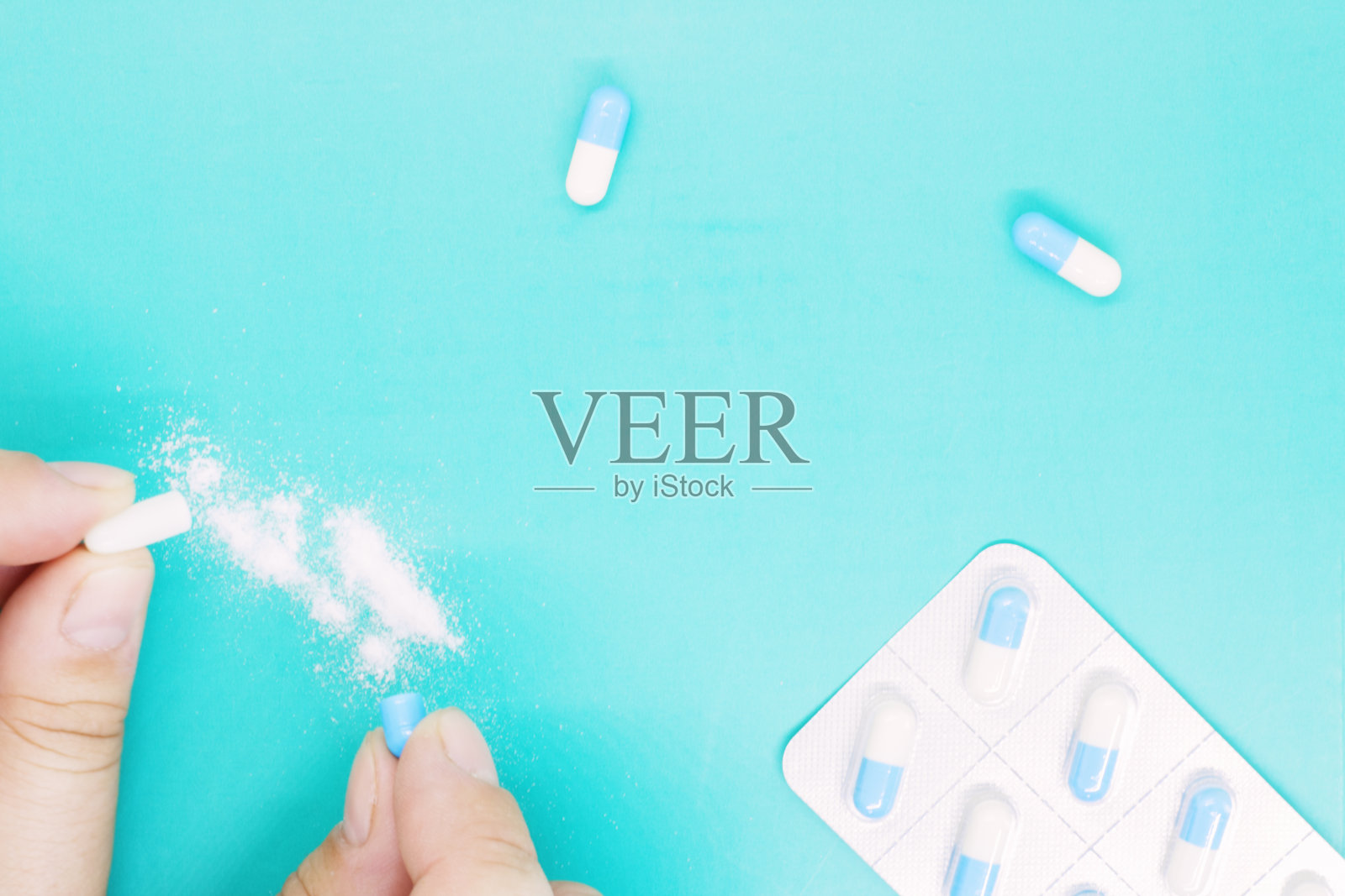 开胶囊用女性的手，片剂用女性的手，白色胶囊特写，片剂用胶囊里面的白色粉末，包衣药、制剂、药品、片剂在包装中照片摄影图片