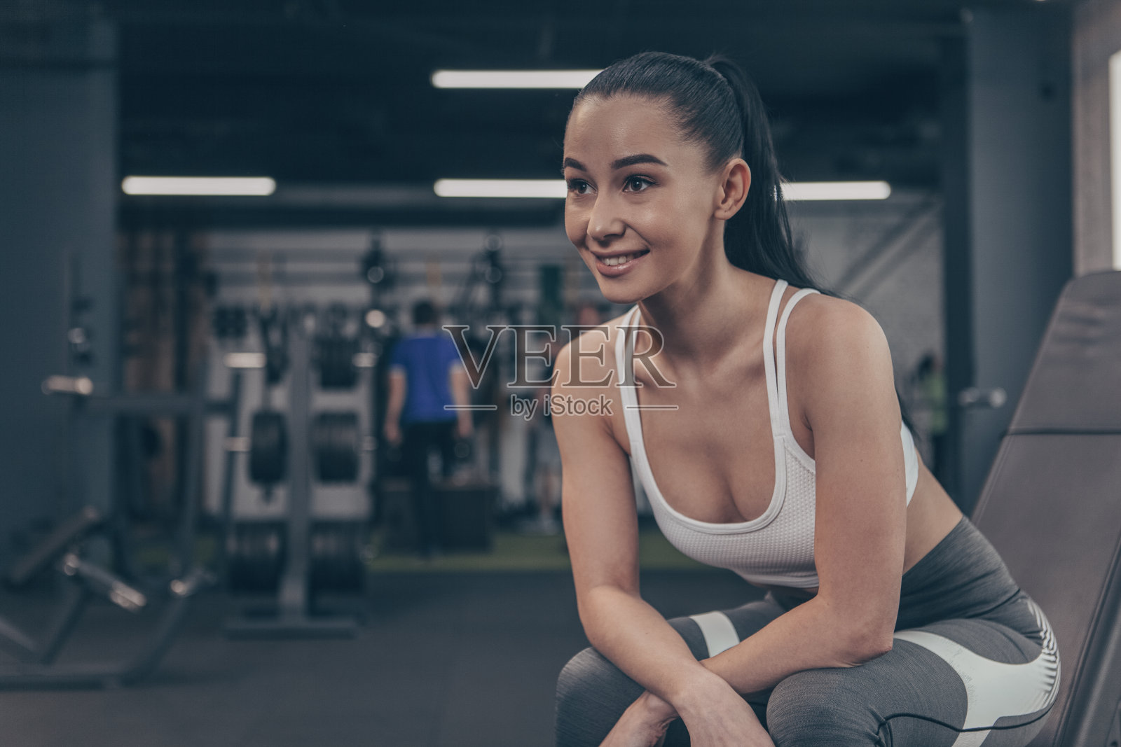 年轻漂亮的女运动员在健身房锻炼照片摄影图片