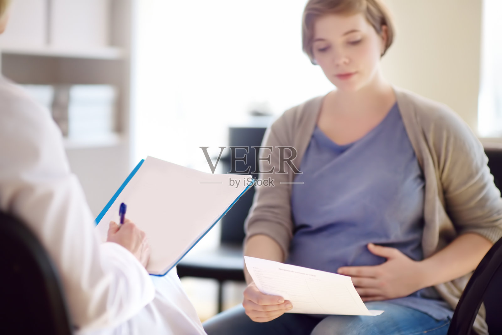 妇产科医生接受孕妇并帮助制定生育计划。生育医疗保险。产假。照片摄影图片