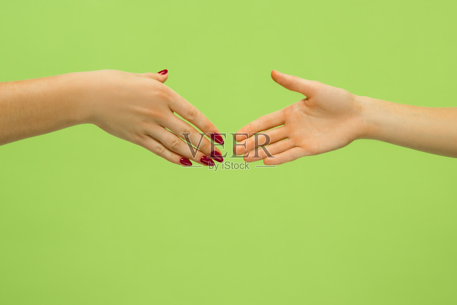 近距离拍摄的人的手孤立在绿色工作室的背景。照片摄影图片