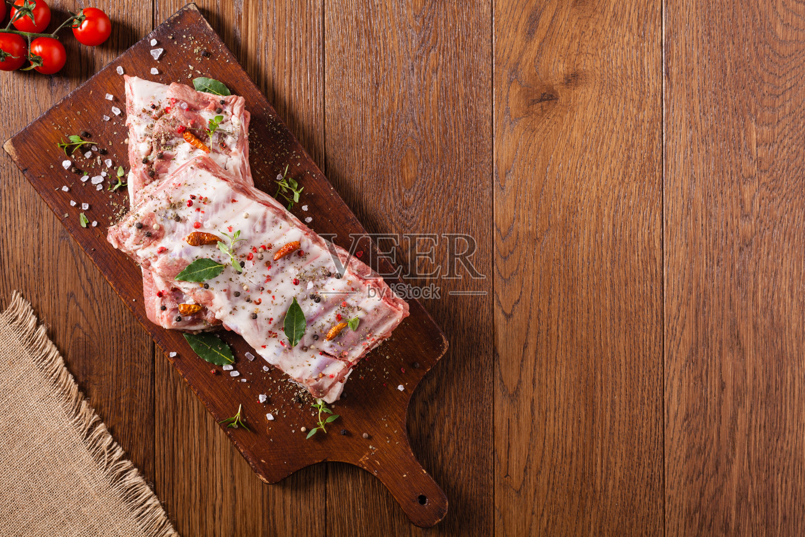 生排骨，在盘子上撒上香料。照片摄影图片