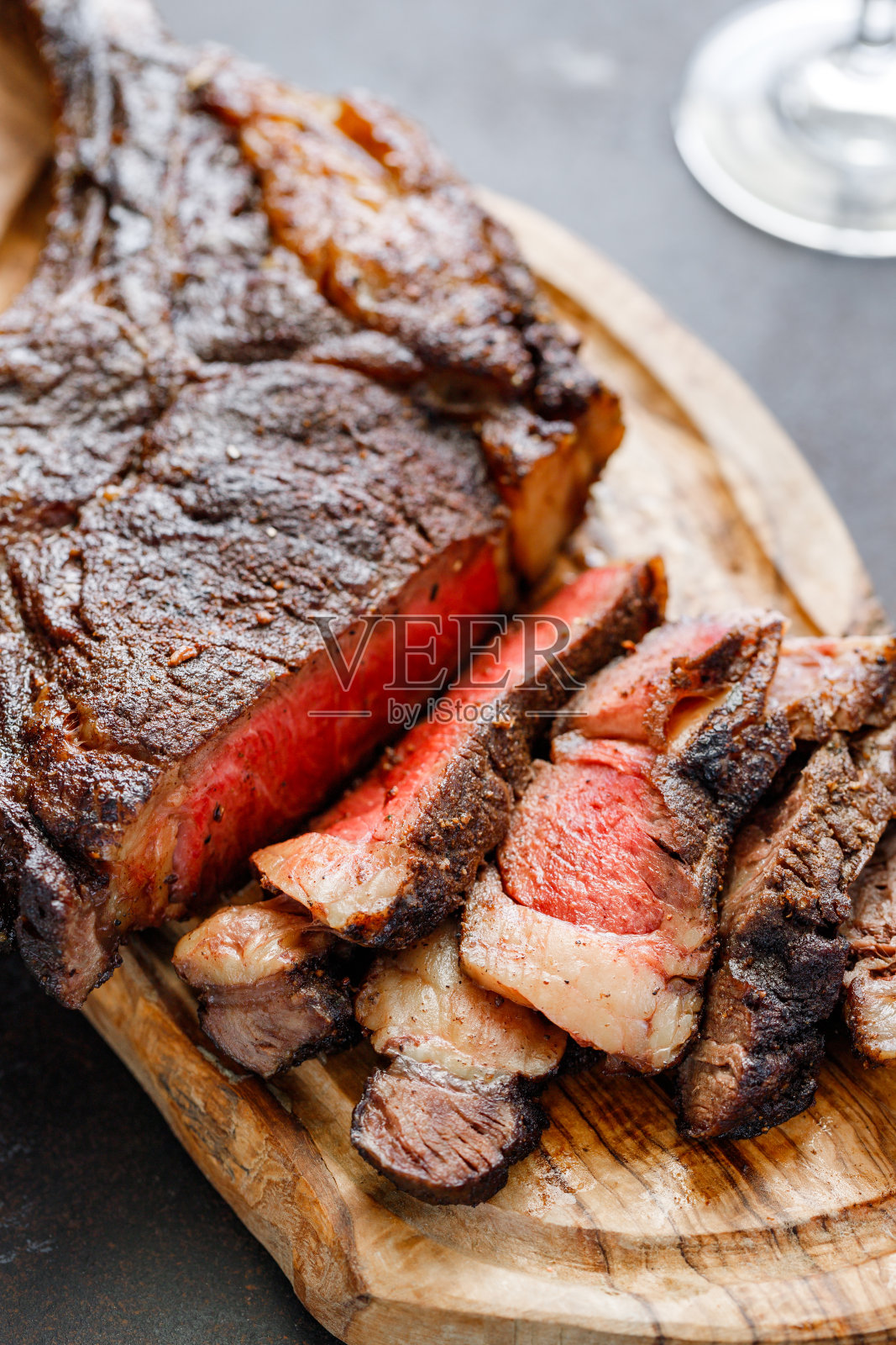 烤干陈年大理石牛排在木板上与香料战斧。特写,晚餐的概念。照片摄影图片