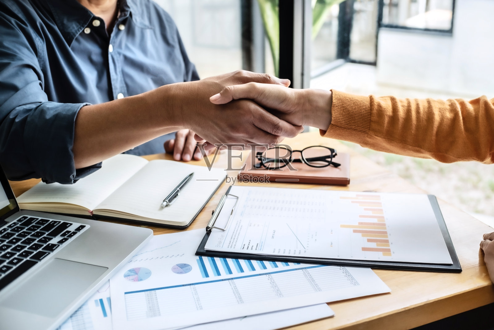 商人在办公室握手。照片摄影图片