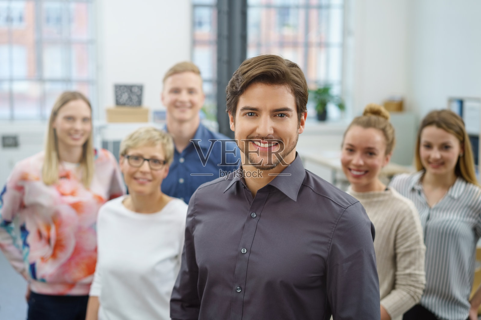 英俊年轻的商业领袖和他的团队照片摄影图片