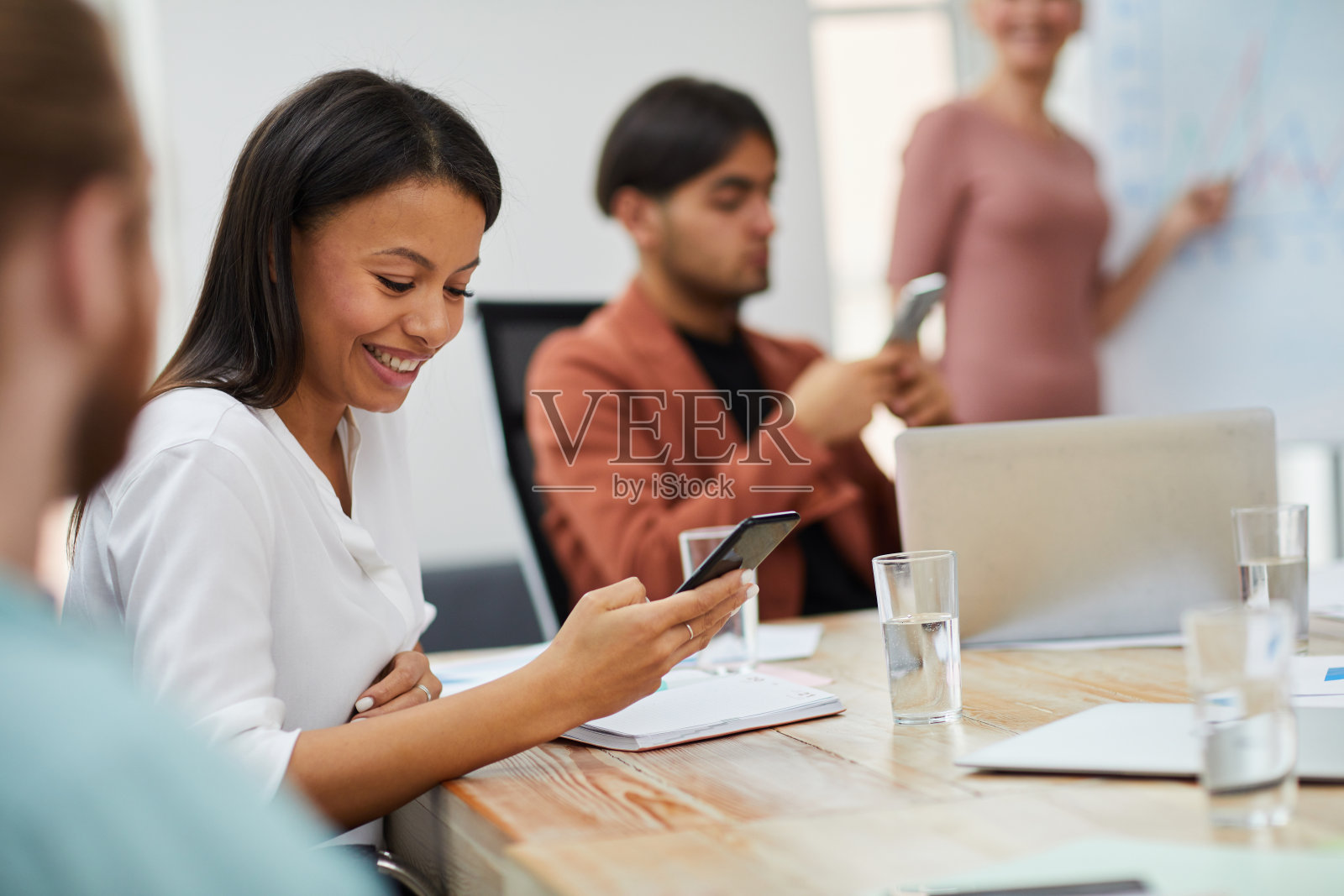 在会议中使用智能手机的女人照片摄影图片