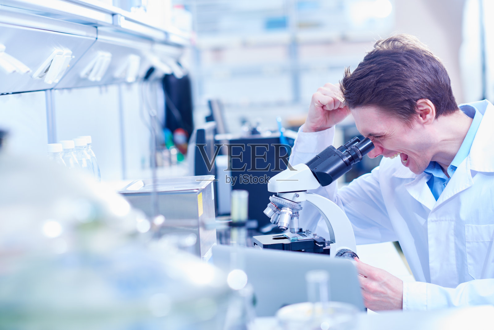 科学家在显微镜下庆祝成功的成果照片摄影图片