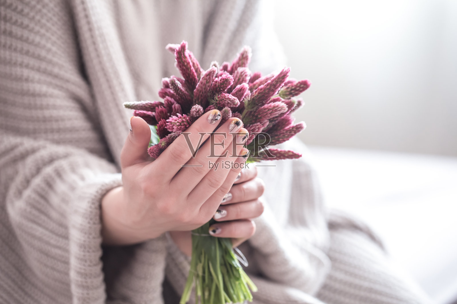 近距离的美丽女性的手拿着大杯卡布奇诺咖啡和鲜花照片摄影图片