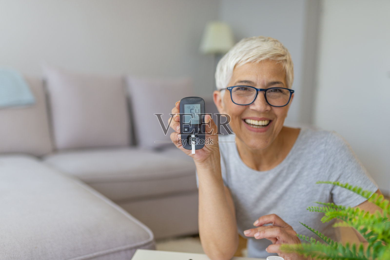 老年妇女在家做血糖检测照片摄影图片