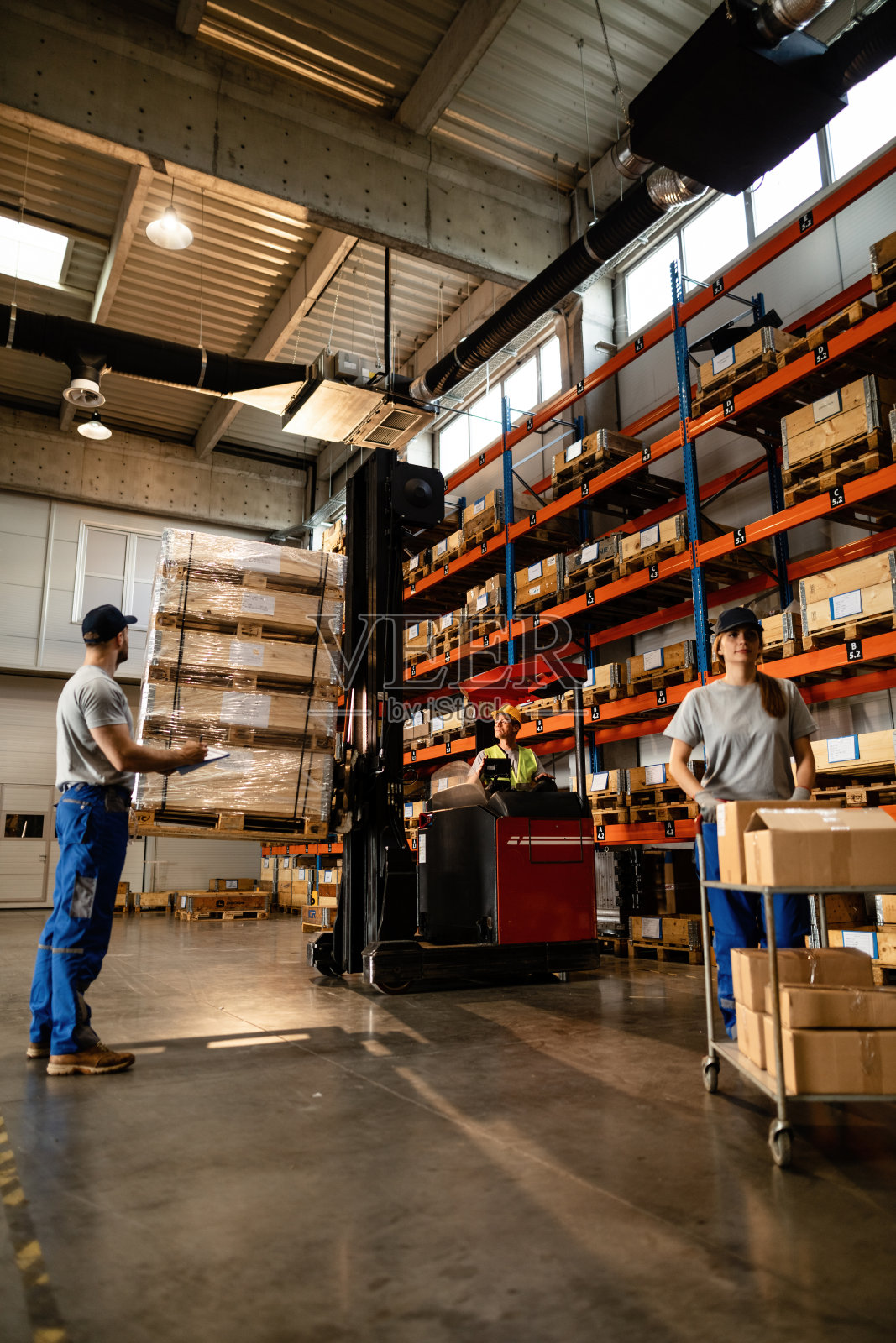 一群在仓库工作的体力劳动者。照片摄影图片