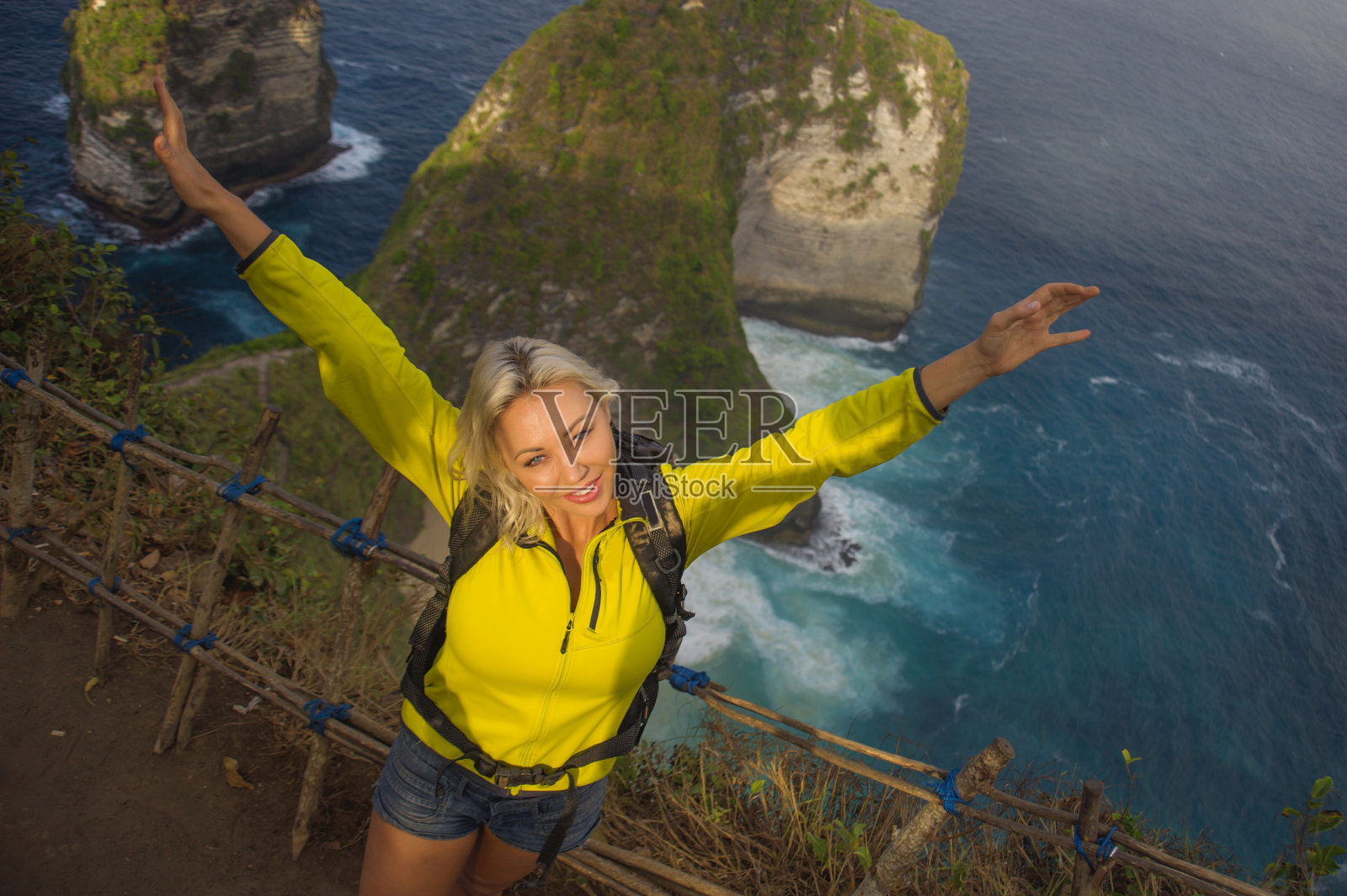 户外生活方式的年轻美丽和快乐的徒步旅行者女人与背包徒步在海边，悬崖探索热带目的地享受独自旅行徒步旅行冒险假期照片摄影图片