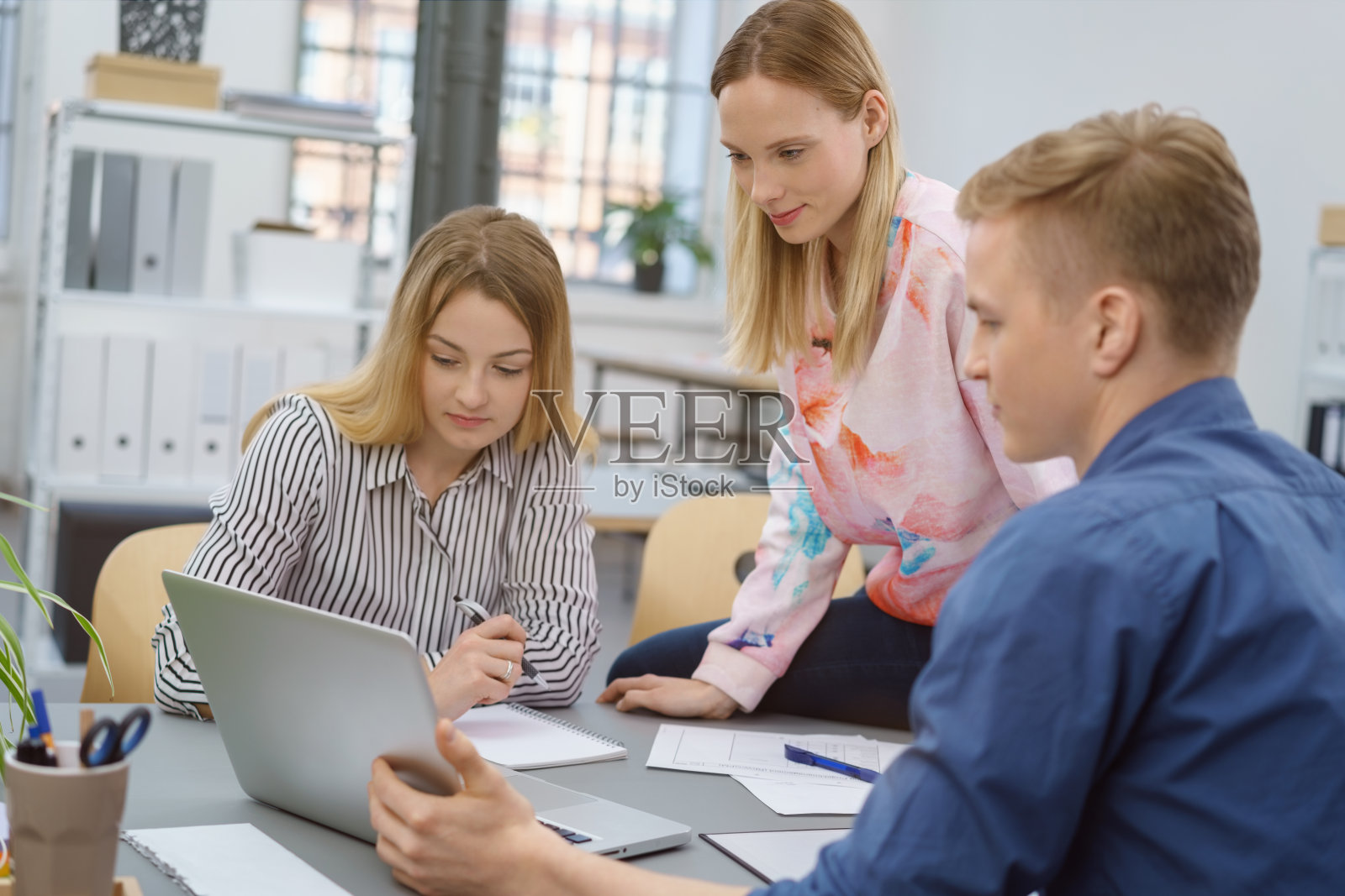 三个同事在用笔记本电脑工作照片摄影图片