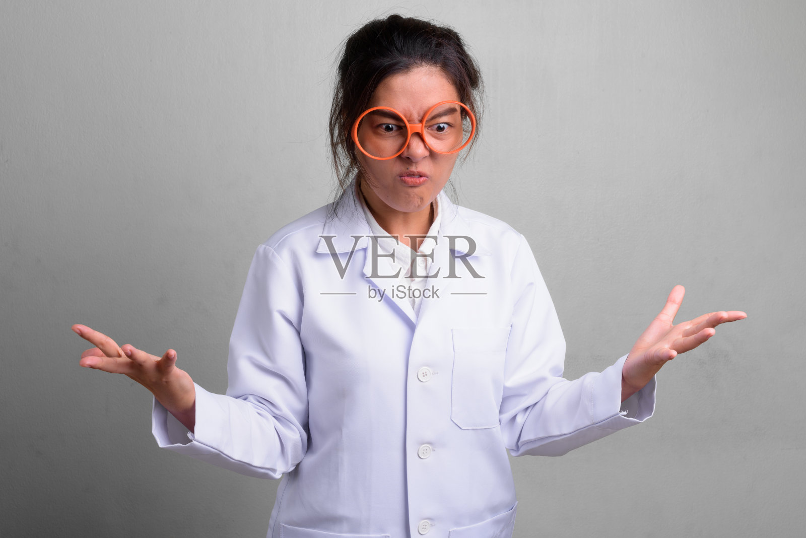 年轻美丽的亚洲女医生疯狂地戴着新奇的眼镜照片摄影图片