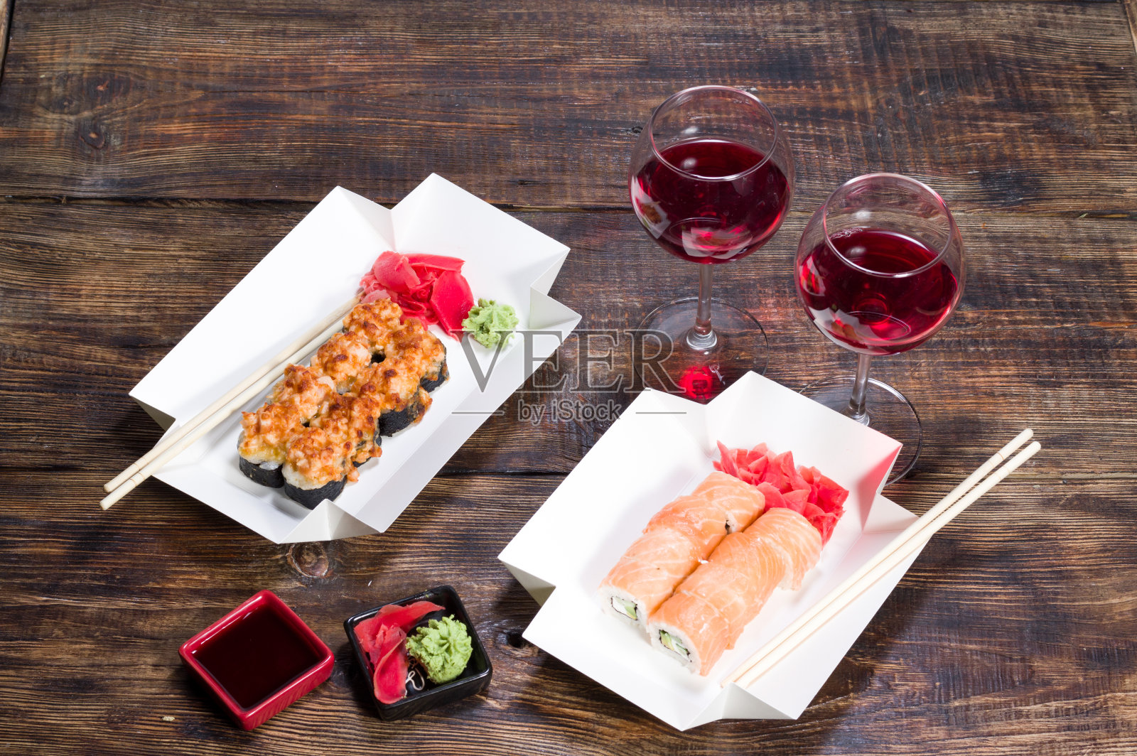 两个人的餐桌。两杯红酒和两份寿司。照片摄影图片