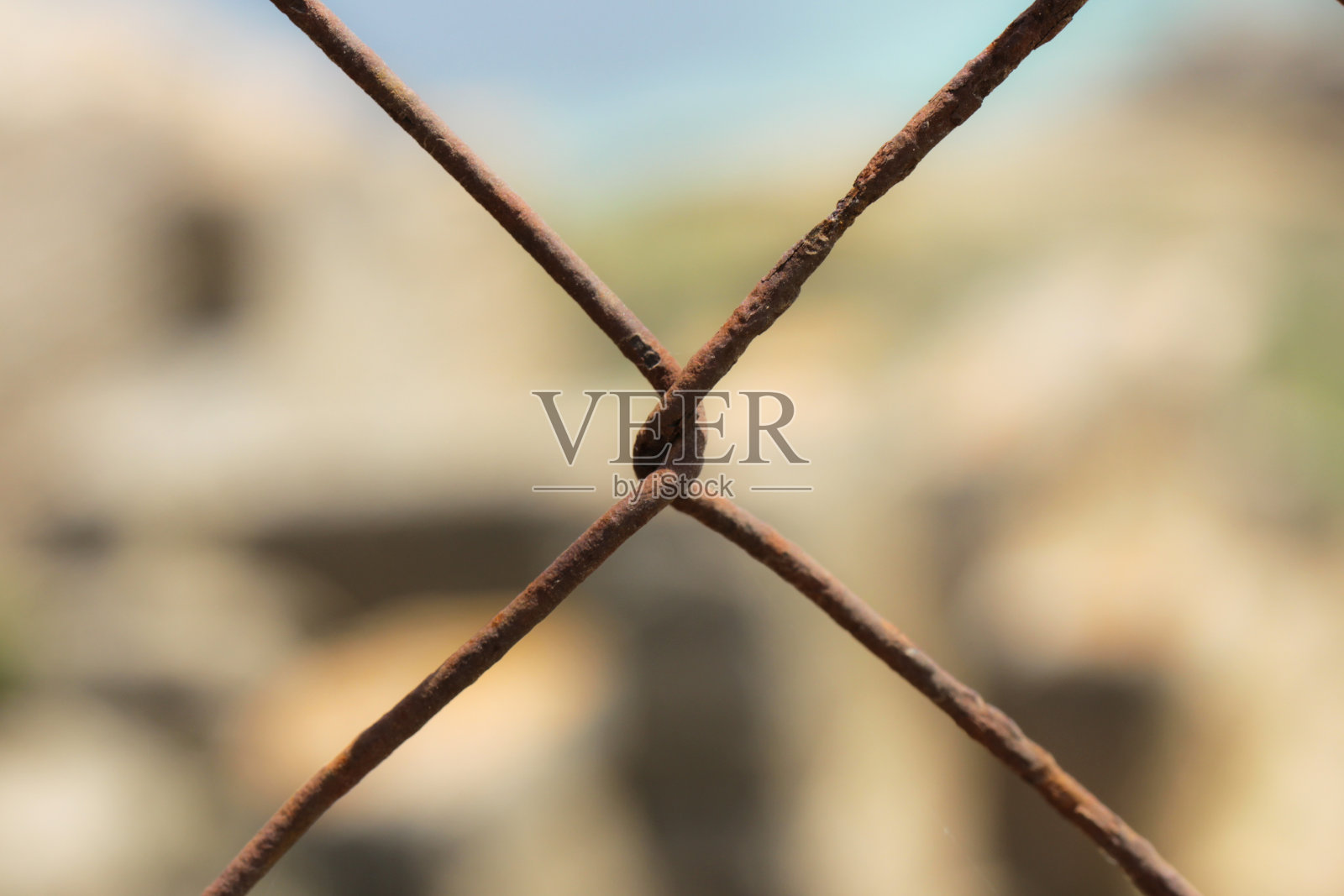 生锈的铁丝扭曲成X的形状照片摄影图片