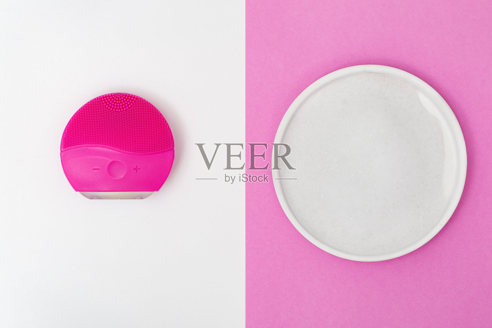 皮肤护理。用脸部刷清洁皮肤和清洁空气泡沫在粉红色和白色的背景上平铺组合。泡沫清洗。前视图。照片摄影图片