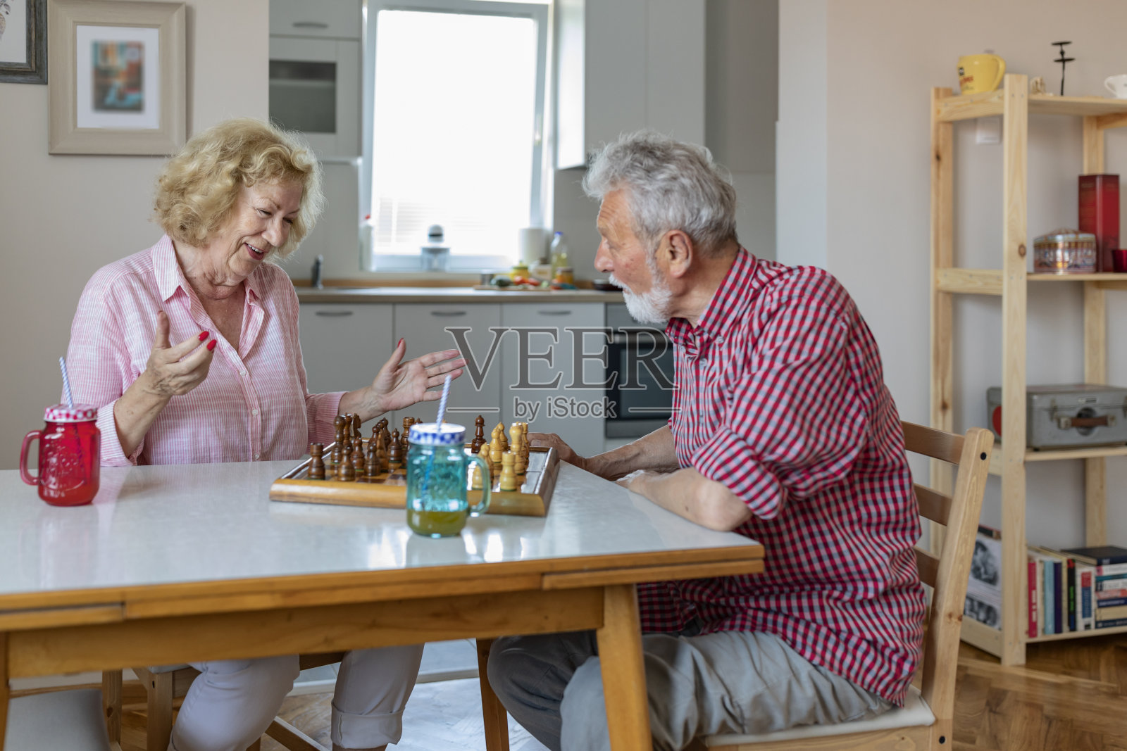老两口在家里下棋照片摄影图片