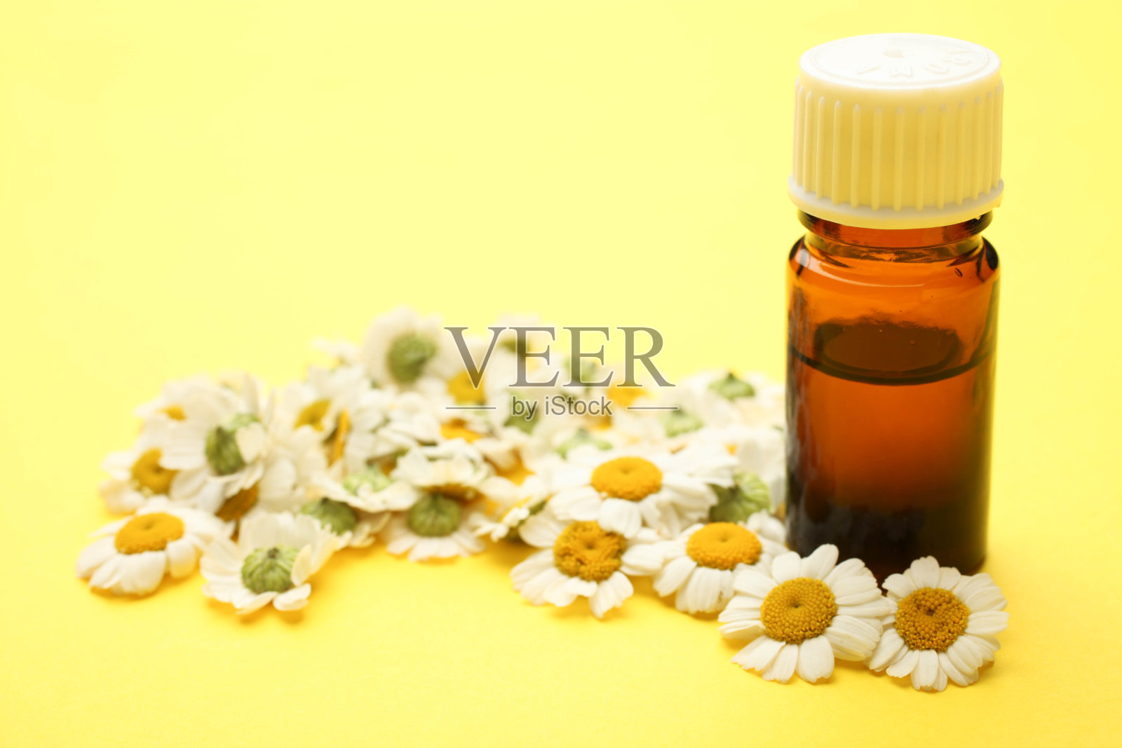 装有香油和菊花的玻璃瓶照片摄影图片