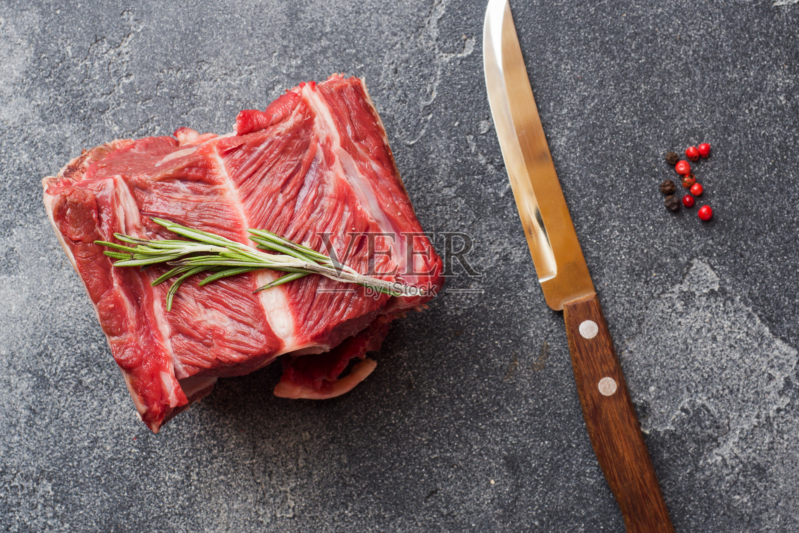 新鲜的生牛肉肋与肉在黑暗的混凝土背景与复制空间。照片摄影图片