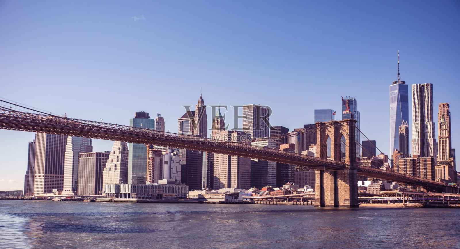 著名的纽约市区天际线，布鲁克林大桥和曼哈顿的摩天大楼照亮了东河全景。纽约,美国照片摄影图片