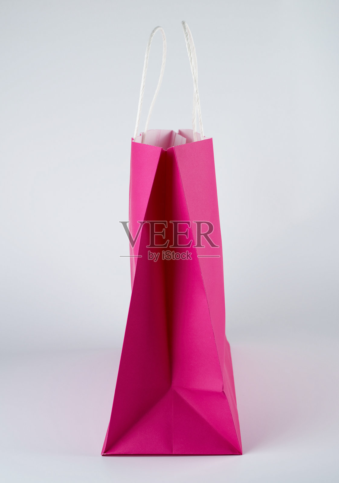 白色背景上有把手的粉色纸袋照片摄影图片