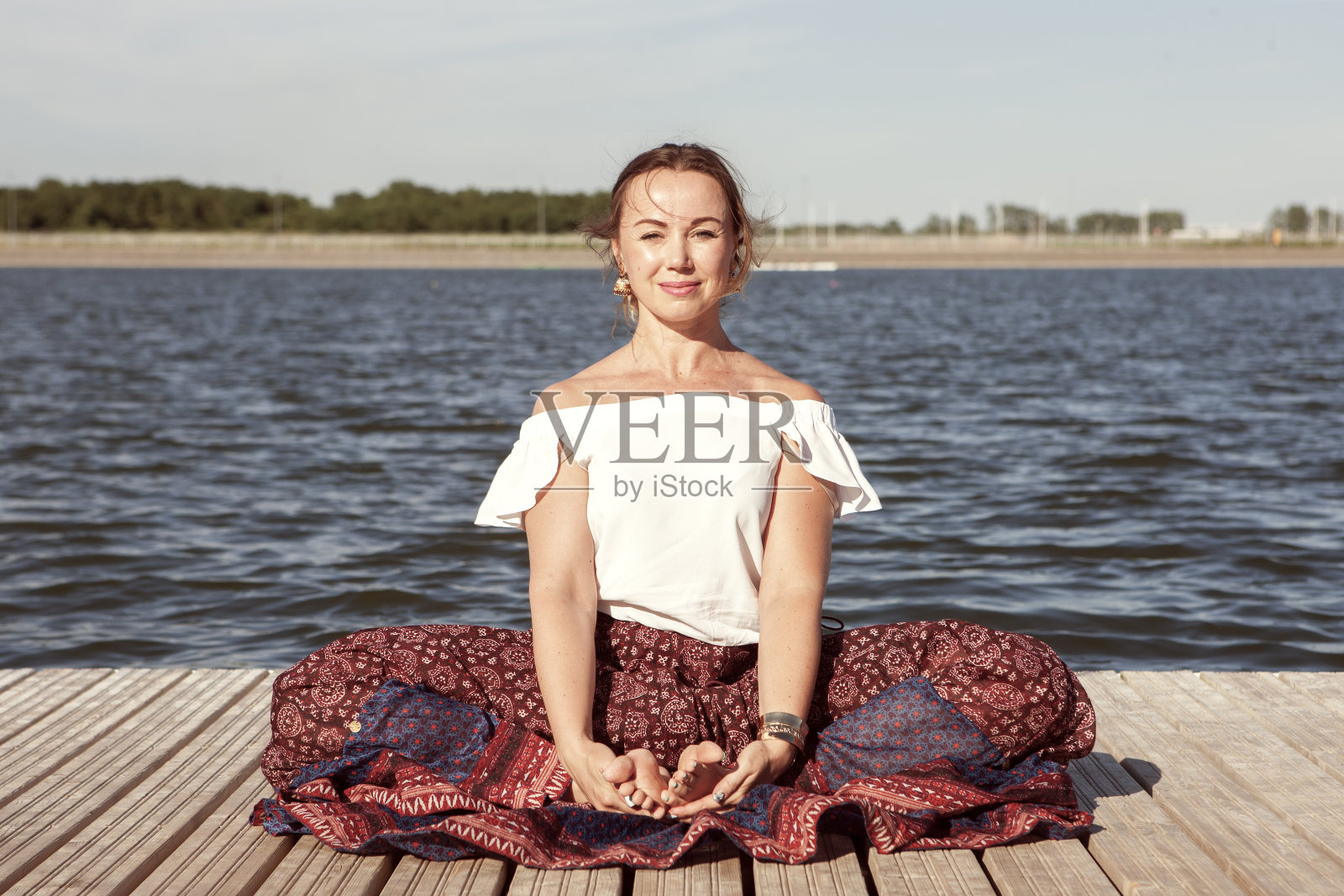 女人在湖上做瑜伽，在大自然中放松照片摄影图片