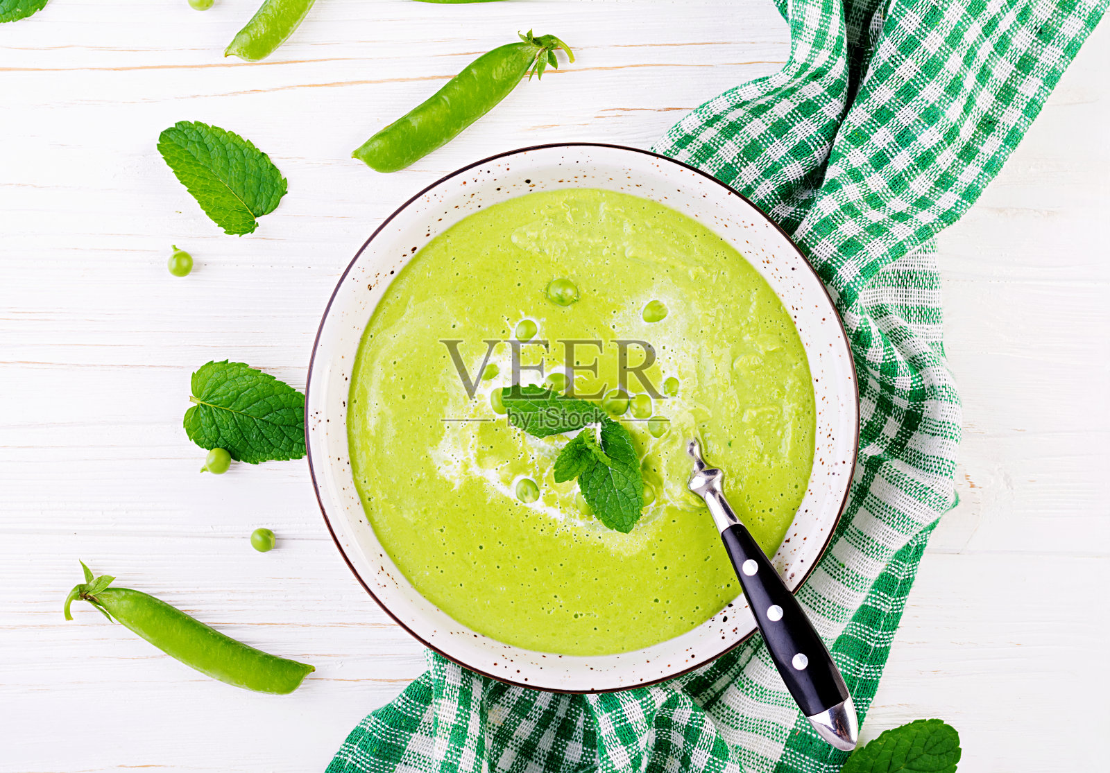 木桌上碗里的豌豆汤。法国菜。俯视图照片摄影图片