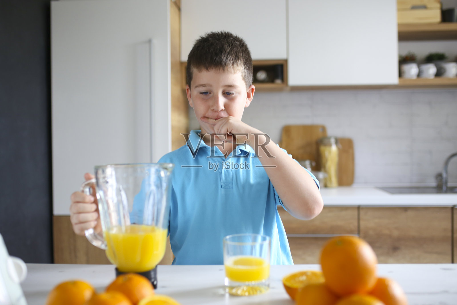喝新鲜橙汁的男孩照片摄影图片
