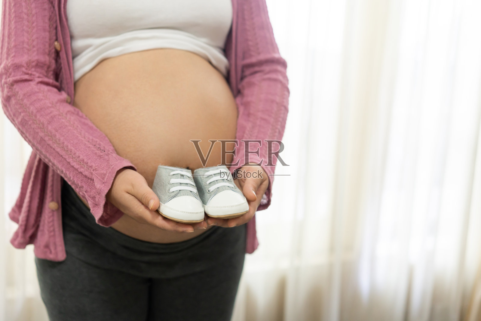 快乐的孕妇和即将出生的孩子在家里。照片摄影图片