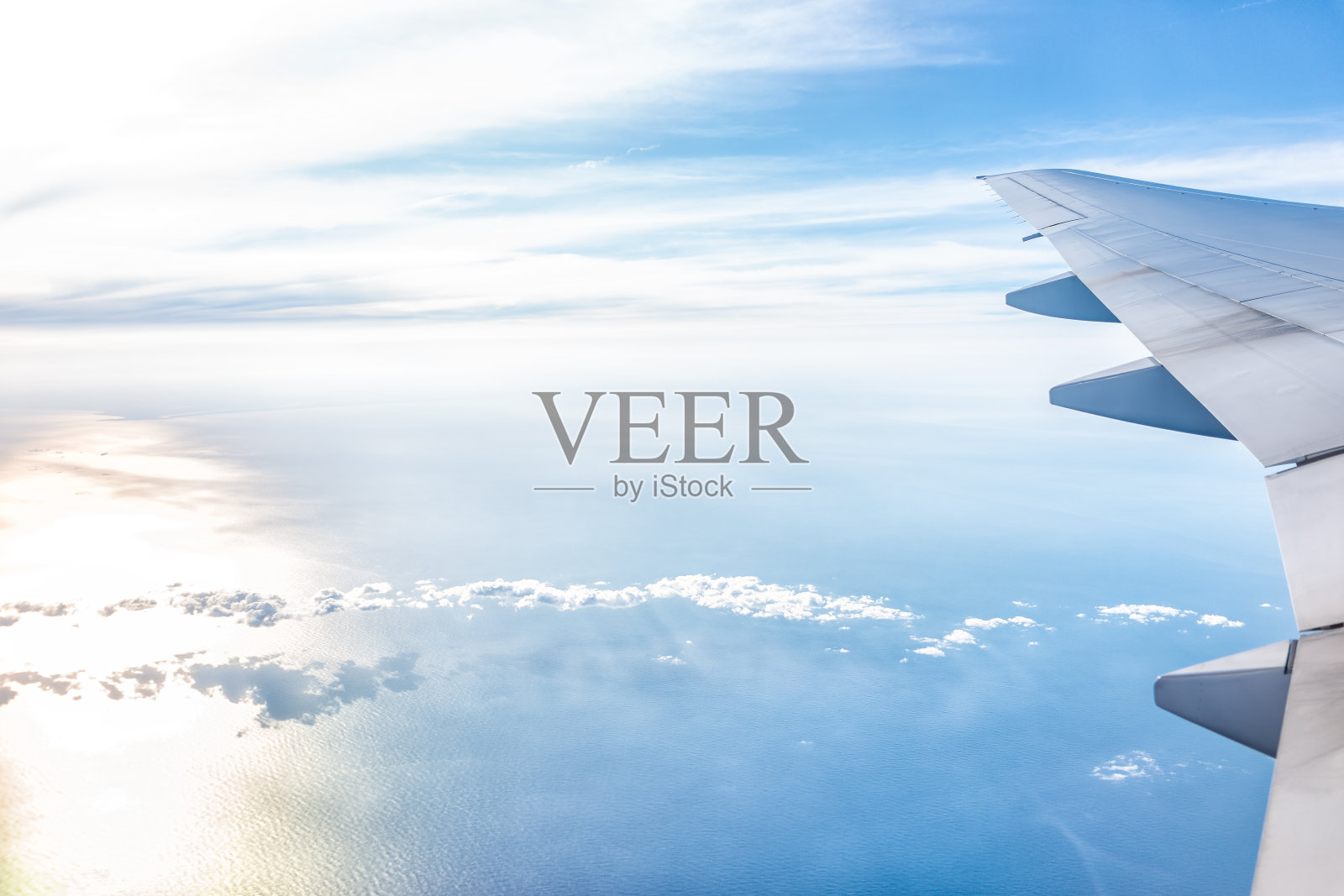 白色飞机在蓝色的天空与从窗户高角度在晴天与飞机机翼和太阳日落在地平线与光的路径照片摄影图片