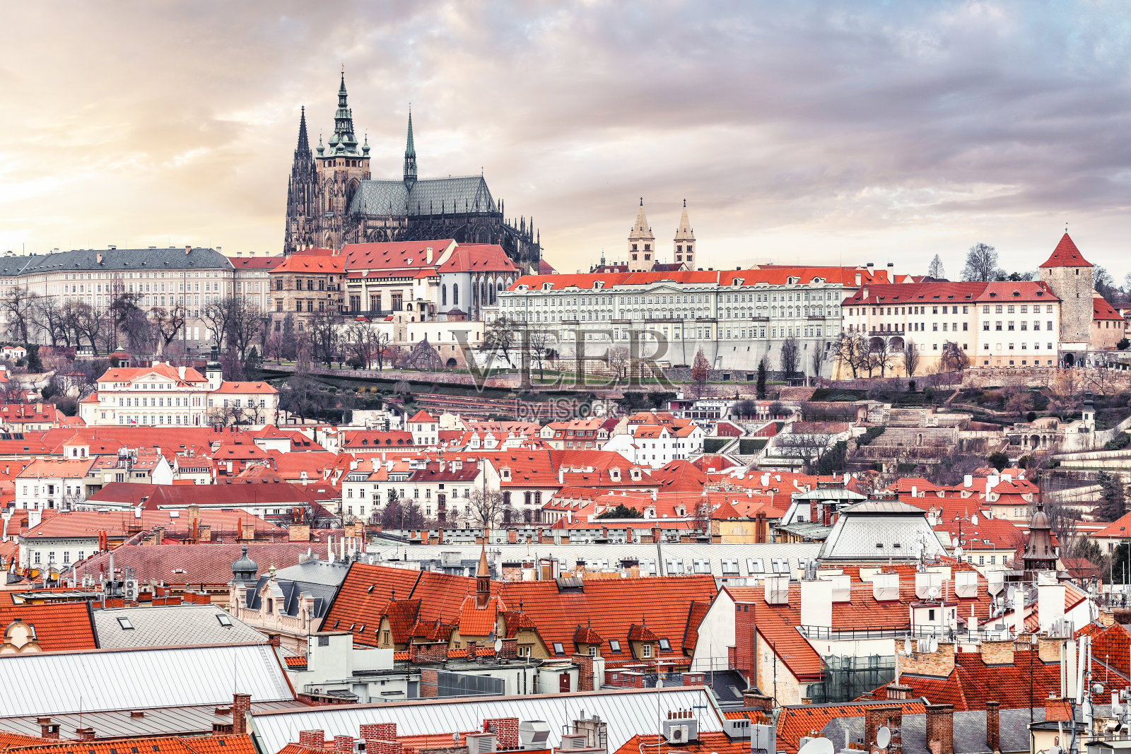 布拉格城堡与圣维图斯圆形建筑的远摄，周围是橙色瓦屋顶的房屋照片摄影图片