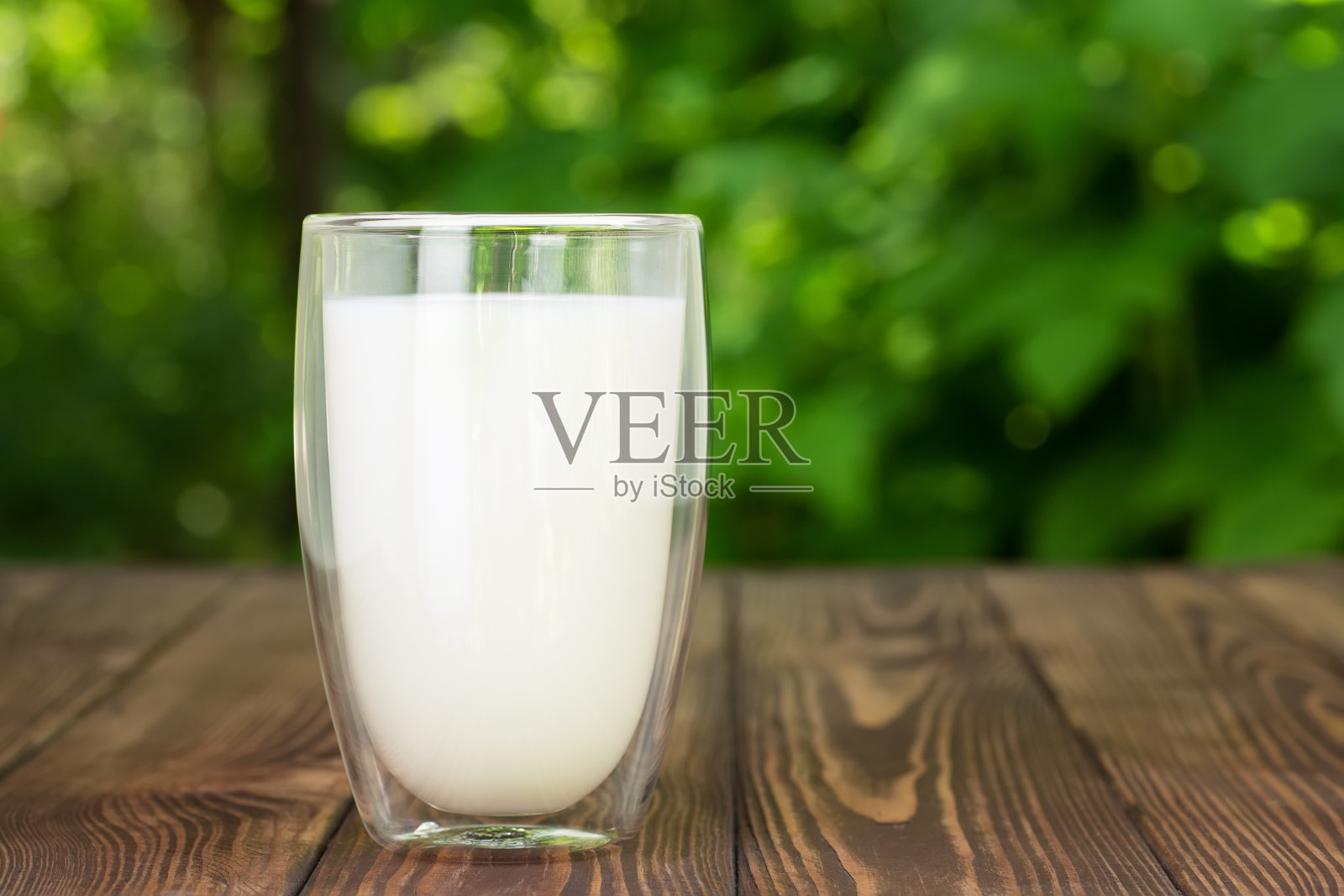 桌上的玻璃杯里装着牛奶照片摄影图片