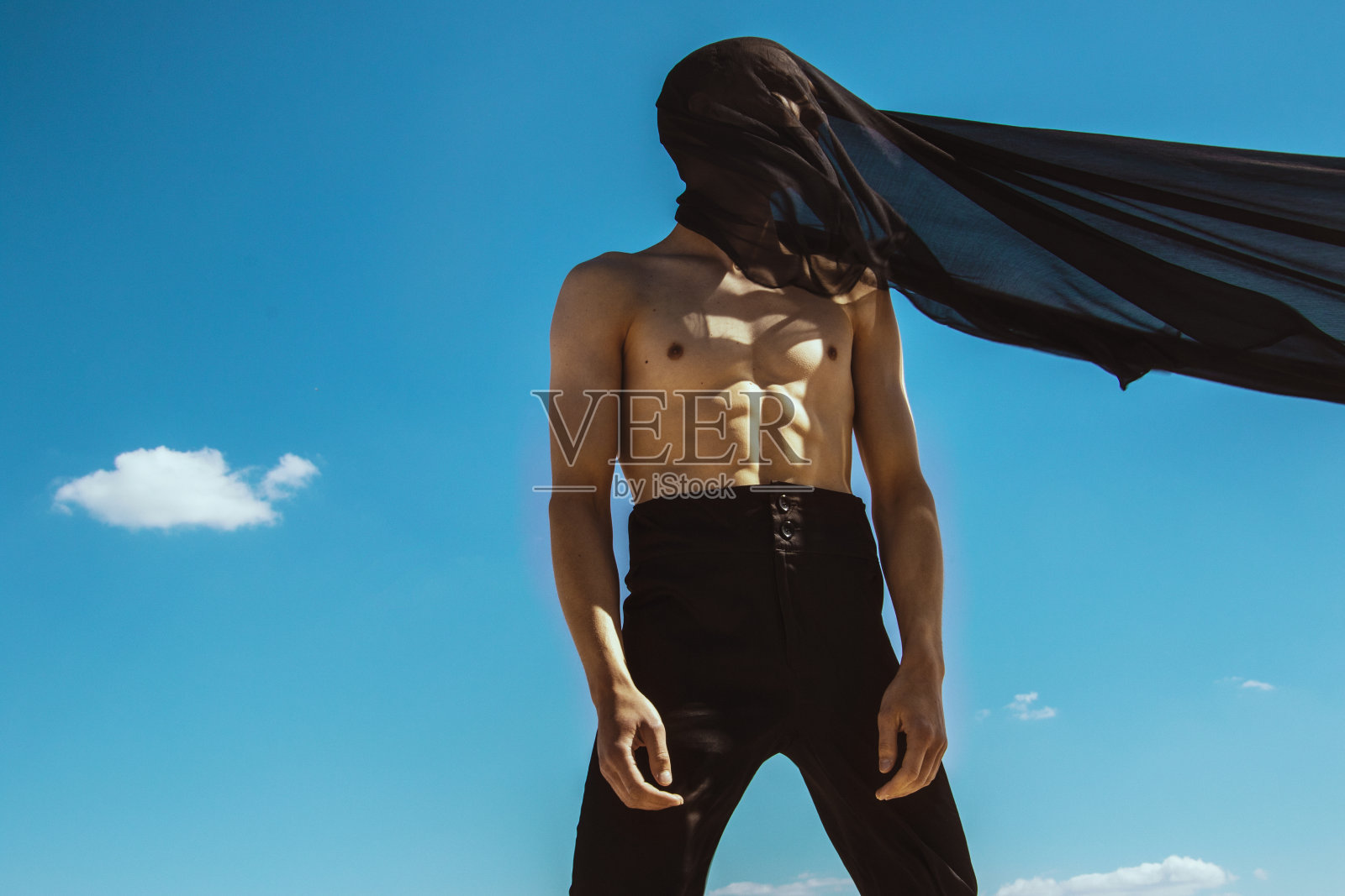 坚强的脸男性模特肖像上的自然背景在清澈的蓝色海水和海滩上的日落照片摄影图片