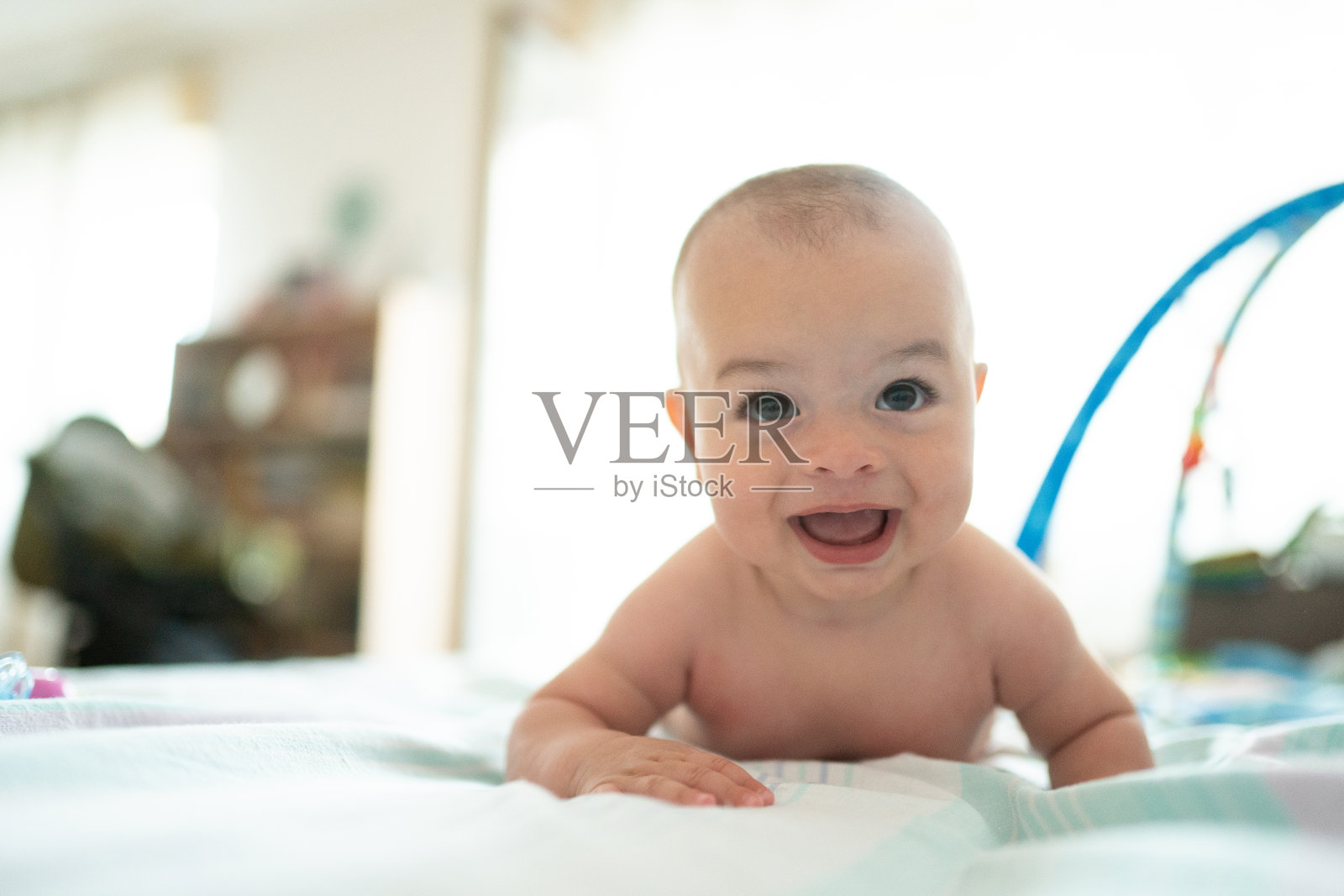 快乐的小男孩躺在家里的床上照片摄影图片