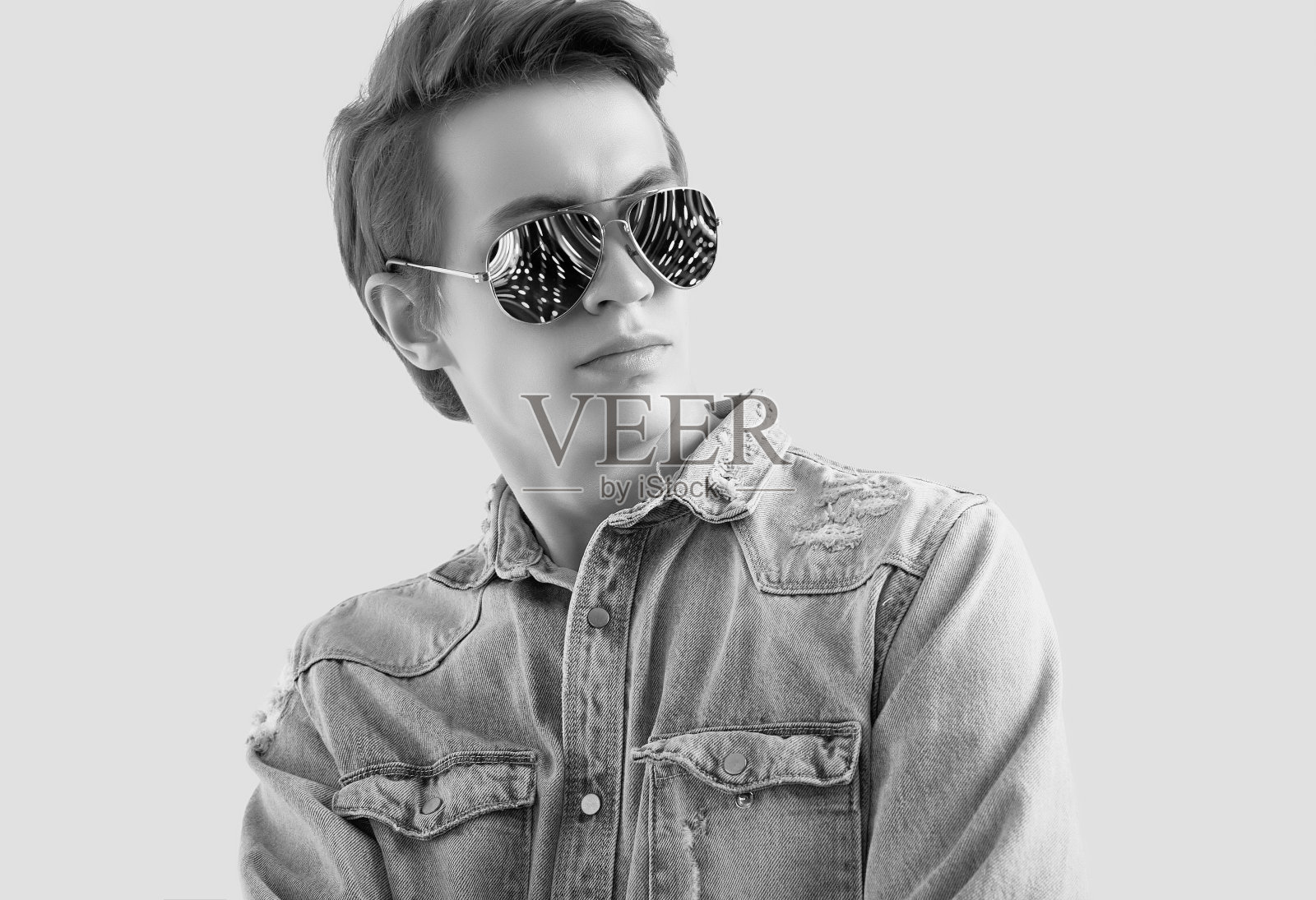 帅气的潮人戴着时尚太阳镜，穿着牛仔裤夹克照片摄影图片