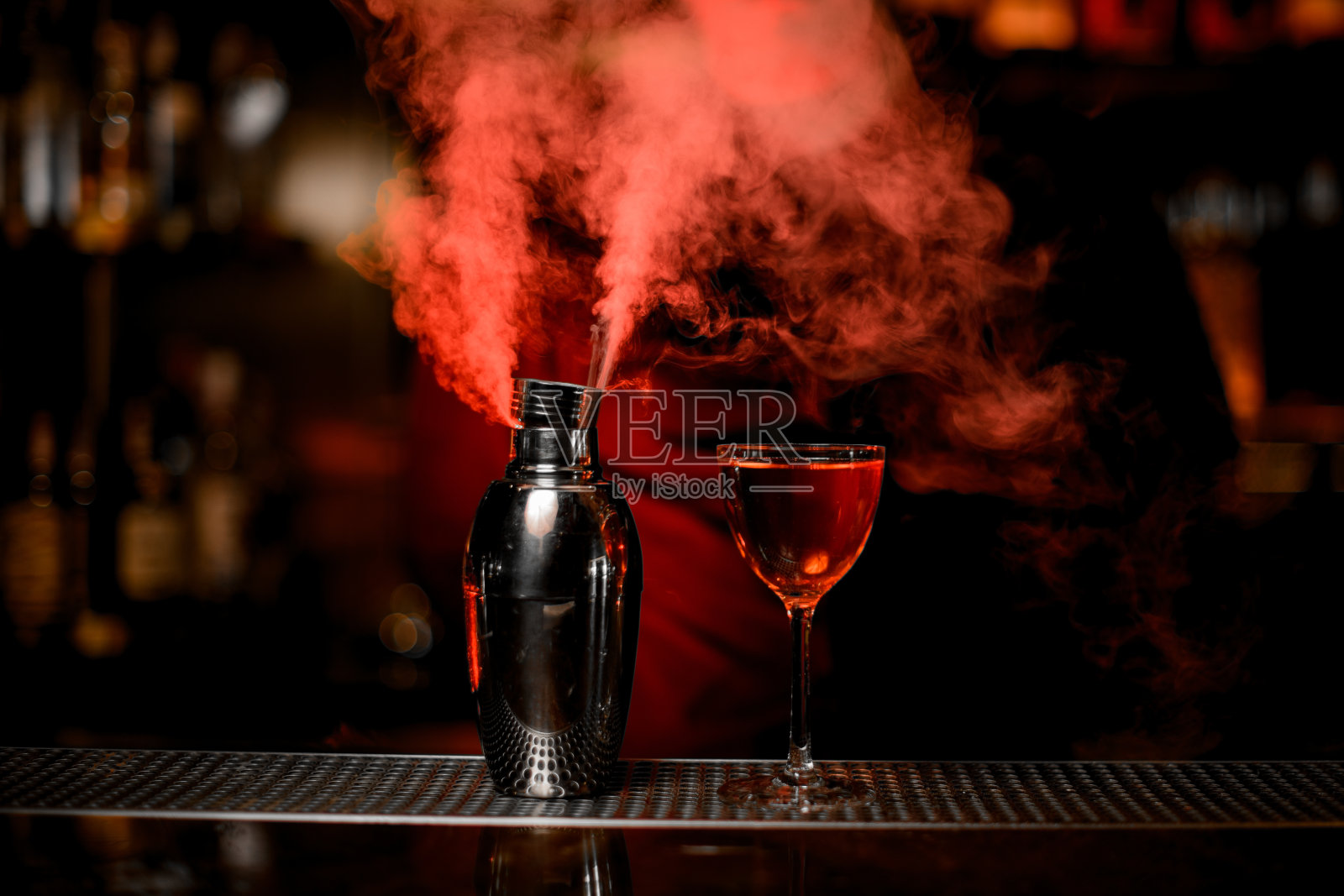 吧台上有吸烟鸡尾酒和酒精鸡尾酒照片摄影图片