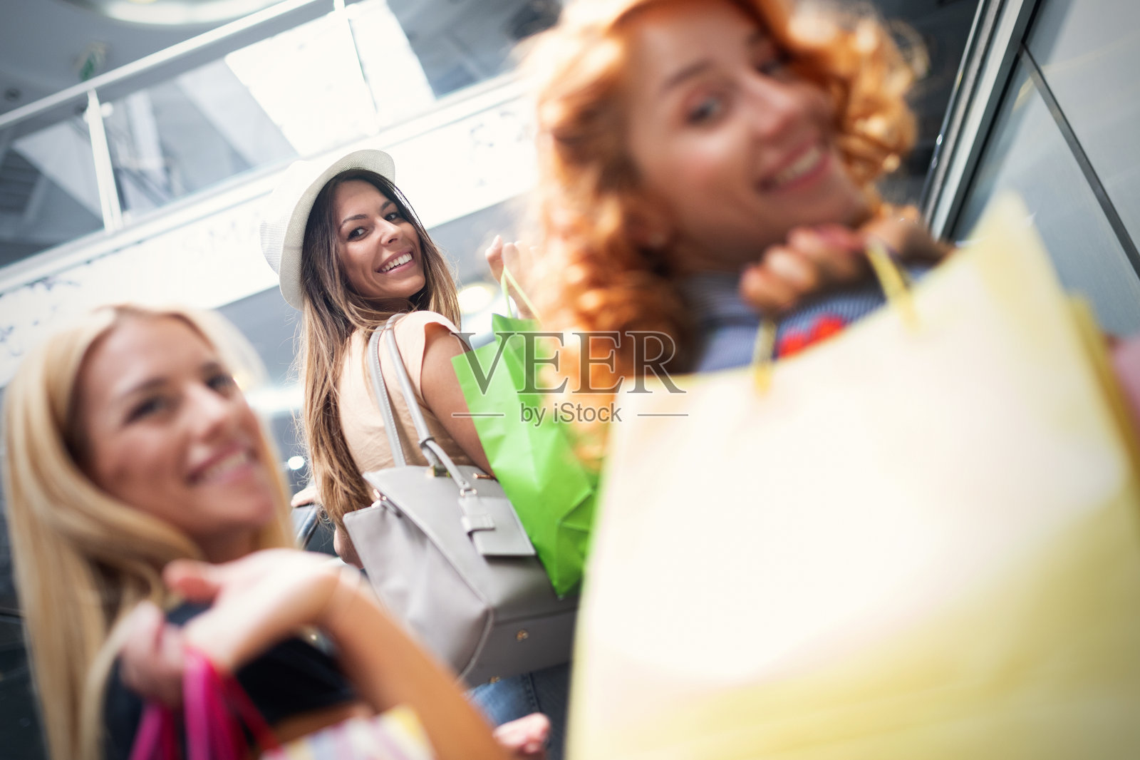 美丽快乐的女孩拿着购物袋，在户外微笑照片摄影图片