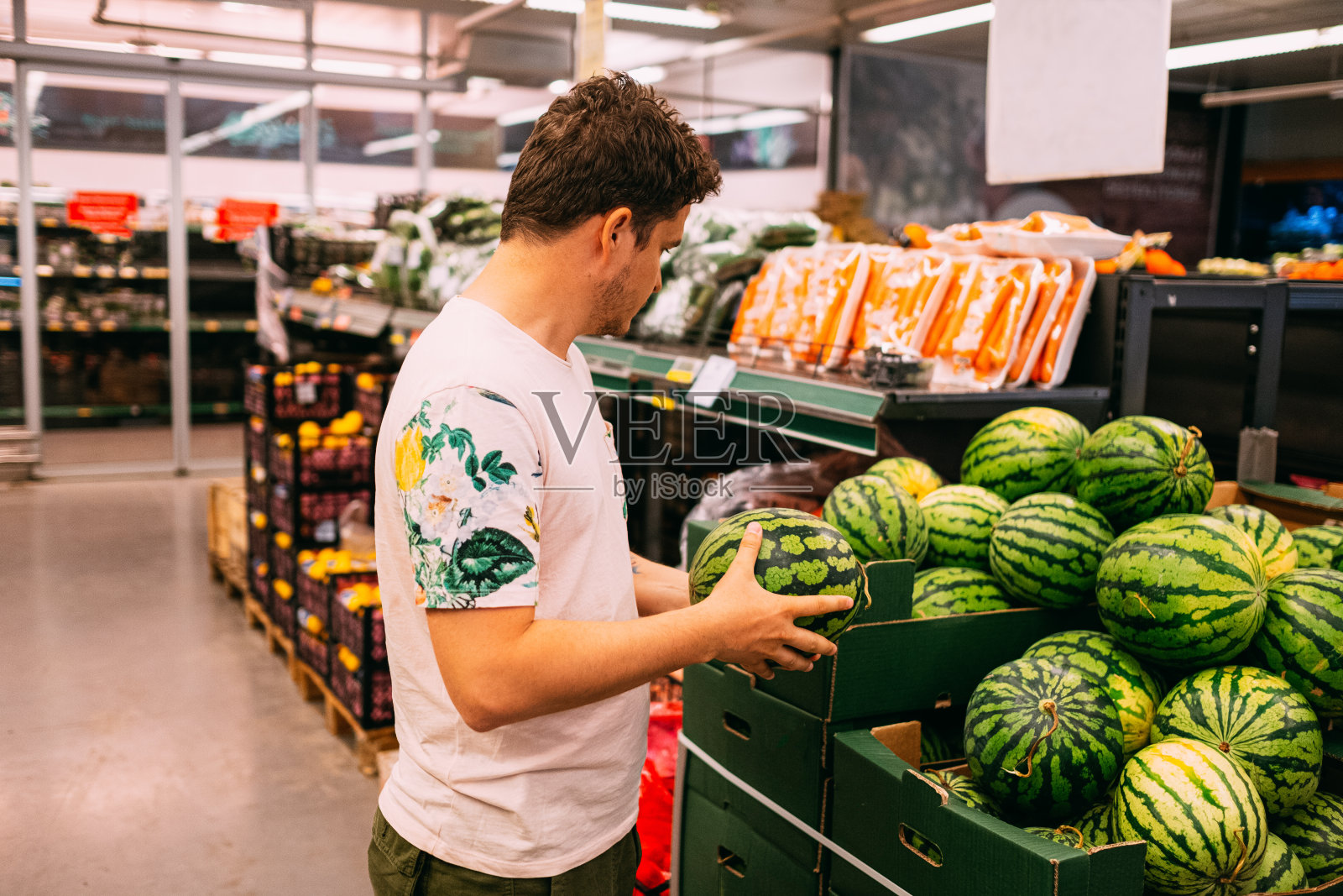 一个年轻人在市场上买西瓜照片摄影图片